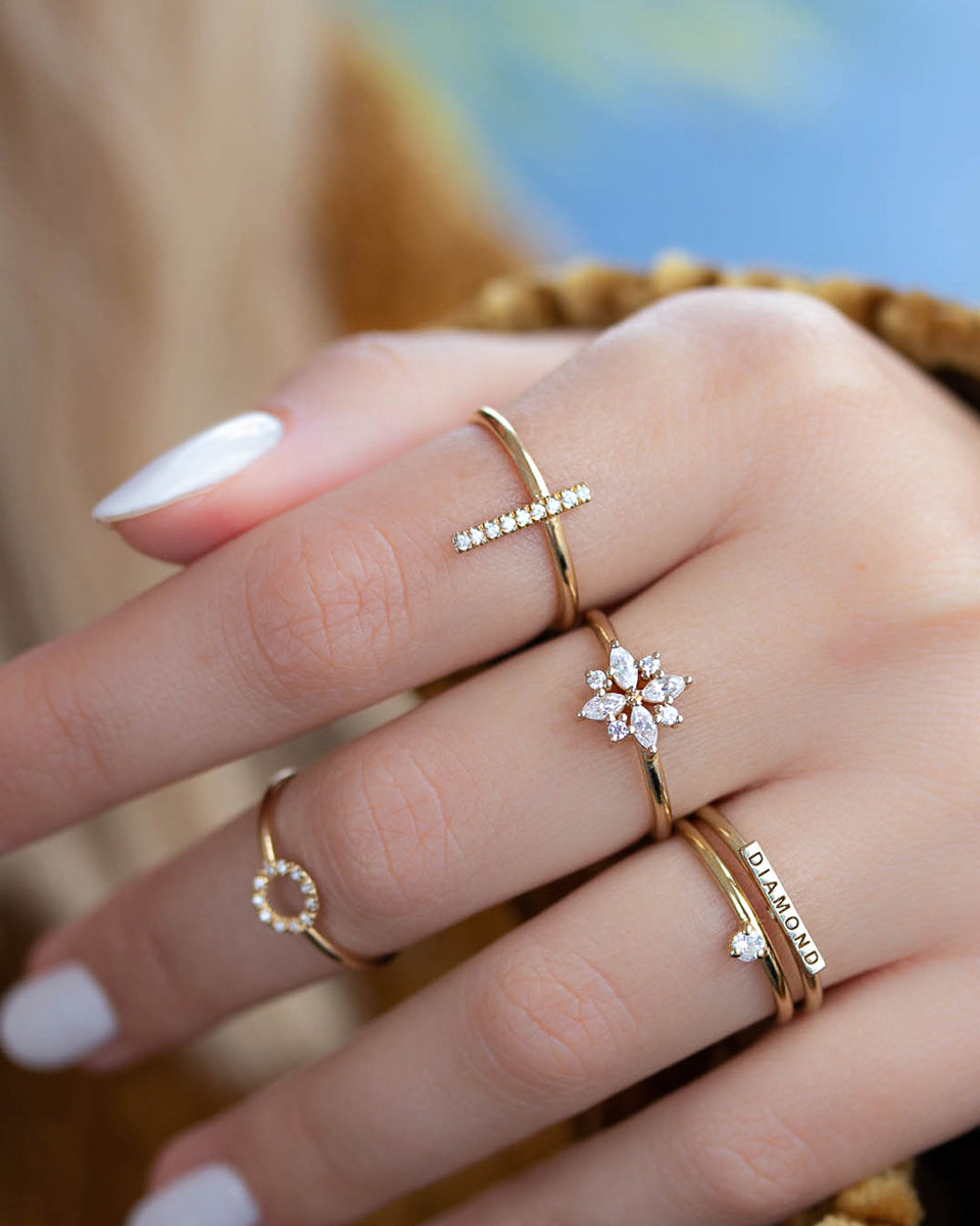 A delicate 14k yellow gold engagement ring set with four marquise cut white diamonds, and four brilliant cut white diamonds, in a shape of a snowflake.