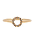 A dainty 14k yellow gold ring with a circle on top, set with brilliant cut white diamonds.