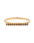 A dainty 14k yellow gold ring, with a horizontal bar on top, set with ten tiny white diamonds.