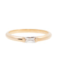 A 14k yellow gold engagement ring, set with a 0.25 baguette cut white diamond.