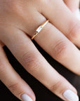 A  delicate 14k yellow gold engagement ring, set with a 0.25 baguette cut white diamond.