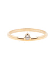 A dainty 14k yellow gold ring, set with one tiny, brilliant cut white diamond.