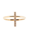 A dainty 14k yellow gold ring, with a vertical bar on top, set with nine tiny white diamonds.