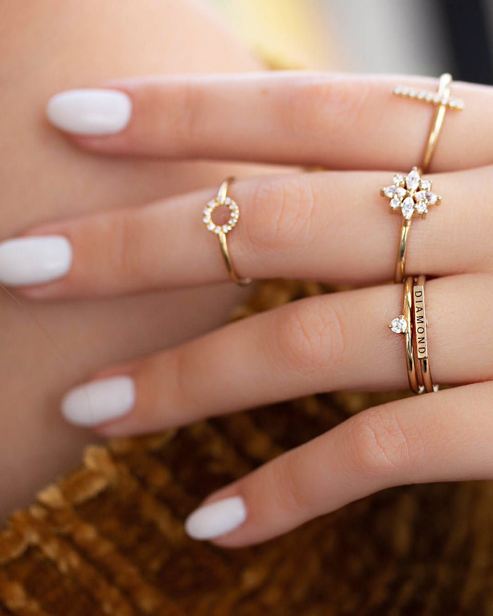 A delicate 14k yellow gold ring, engraved with DIAMOND on top and set with two tiny white diamonds.