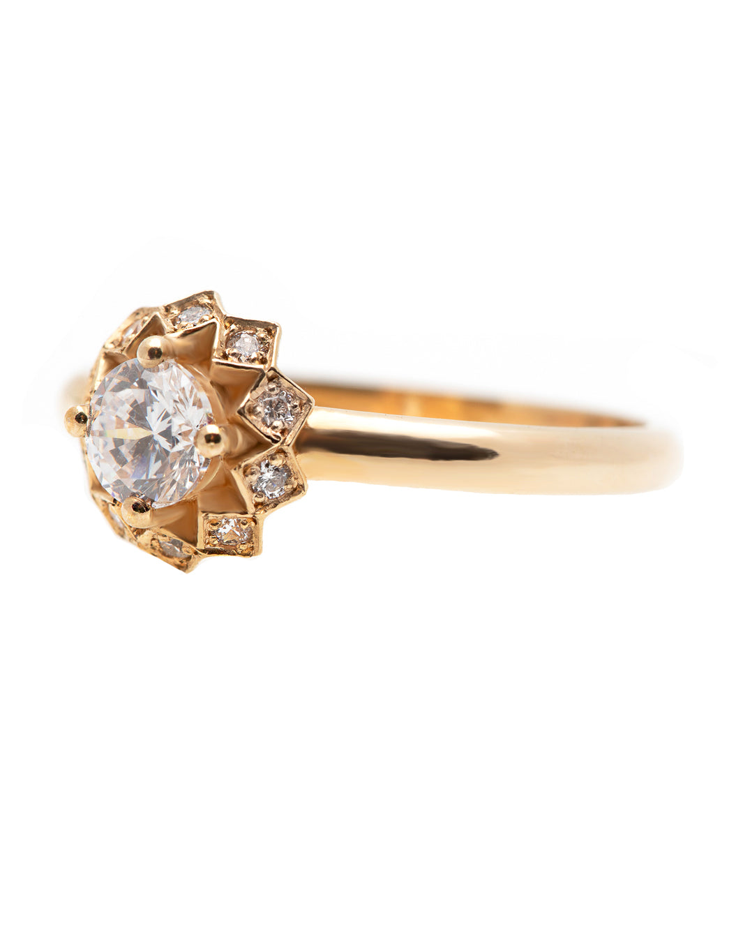A delicate 14k yellow gold engagement ring, set with a center brilliant cut white diamond and smaller diamonds around it, in the shape of a geometric flower. 
