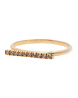 A dainty 14k yellow gold ring, with a horizontal bar on top, set with ten tiny white diamonds. 