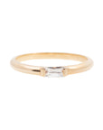 A 14k yellow gold engagement ring, set with a 0.25 baguette cut white diamond. 