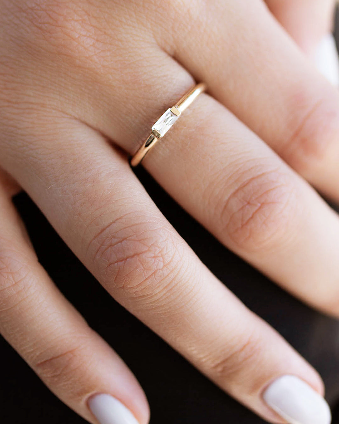 A  delicate 14k yellow gold engagement ring, set with a 0.25 baguette cut white diamond. 
