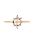 A delicate 14k yellow gold engagement ring set with four marquise cut white diamonds, and four brilliant cut white diamonds, in a shape of a snowflake.